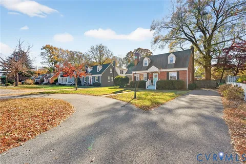 a view of swimming pool with outdoor seating and trees in the background