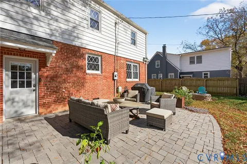 a view of a patio with couches and a table and chairs with wooden fence