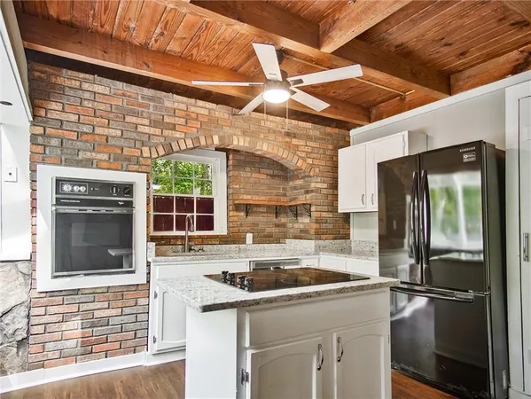a kitchen with stainless steel appliances granite countertop a stove and a white cabinets