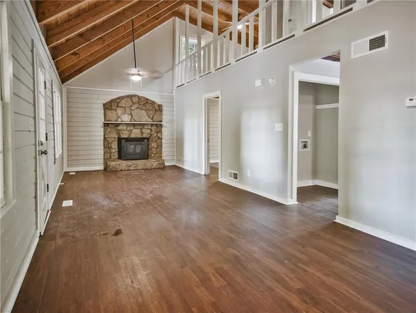 a view of an empty room with a window and fire place