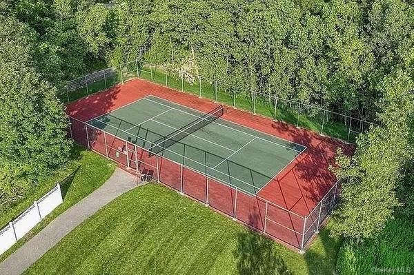 a view of a tennis ground with large trees