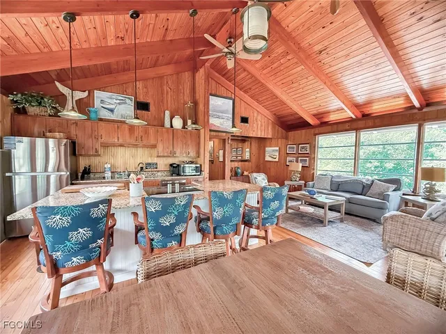 a view of a patio with couches and dining table and chairs with wooden floor