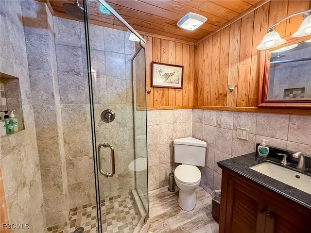 a bathroom with a toilet sink a mirror and shower