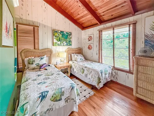 a bedroom with two beds and a large window