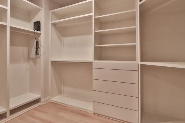 a view of walk in closet with empty racks