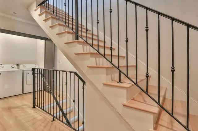 a view of staircase with railing and white walls