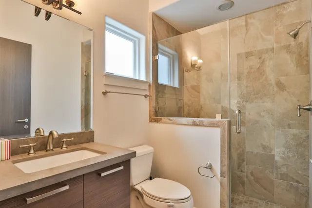 a bathroom with a sink a toilet and shower