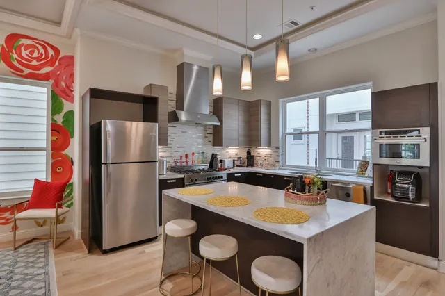 a kitchen with refrigerator and chairs