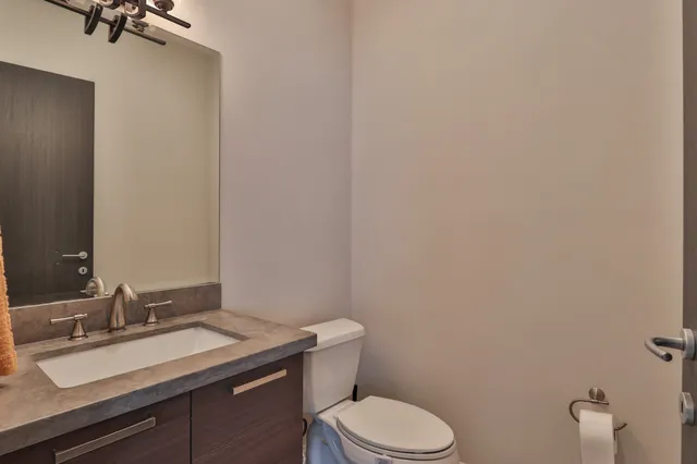 a bathroom with a granite countertop toilet sink and mirror