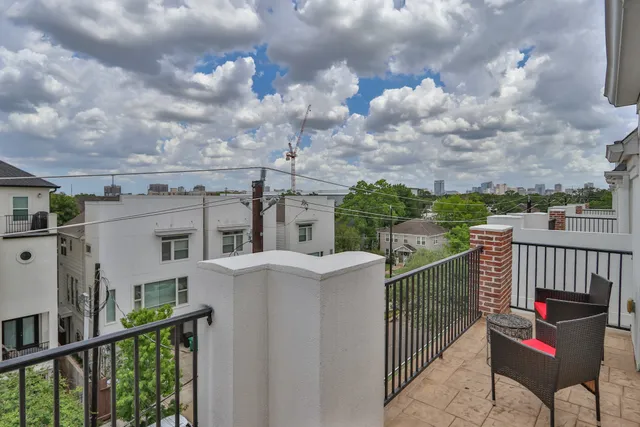 a view of a roof deck with chair and wooden fence