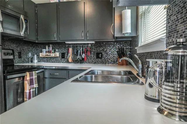 a kitchen with granite countertop a sink a stove and cabinets