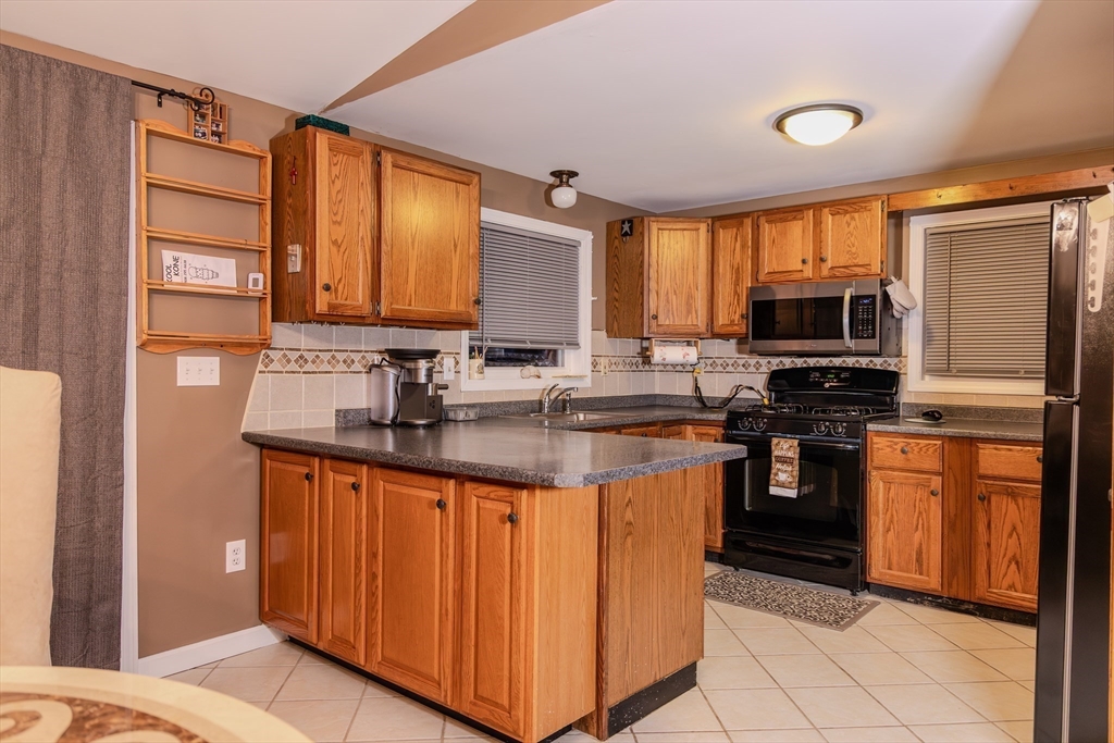 7 Roosevelt Street Wareham, MA 02571 - Photo 10 of 28 a kitchen with stainless steel appliances granite countertop a stove a sink and a microwave