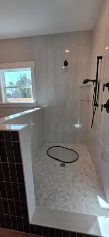 a view of an empty room with wooden floor and a ceiling fan