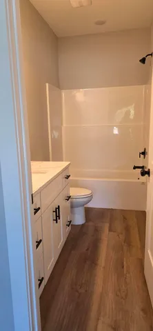 a room with a wooden floor and cabinets