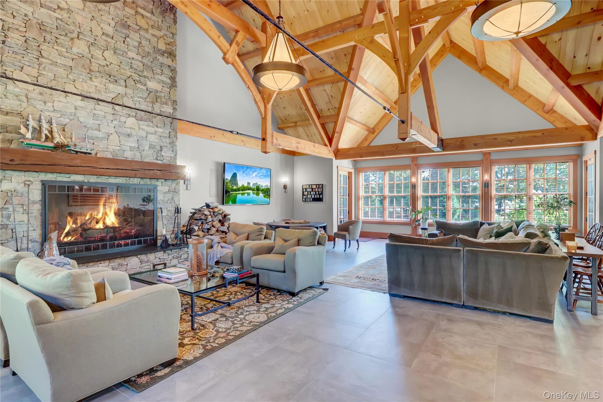63 Dyke Road Setauket, NY 11733 - Photo 21 of 49 Living room with high vaulted ceiling, beamed ceiling, healthy amount of natural light, and a stone fireplace