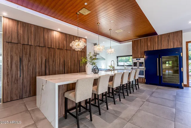a kitchen with stainless steel appliances kitchen island a refrigerator sink and cabinets