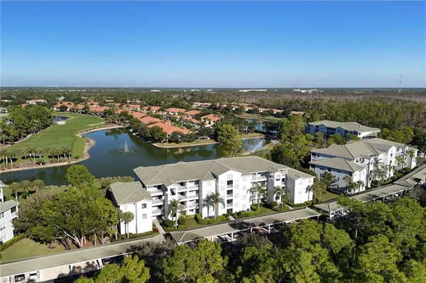 an aerial view of a city with lots of residential buildings ocean and mountain view in back