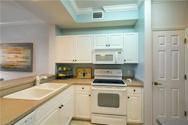 a kitchen with cabinets appliances a sink and a counter top space
