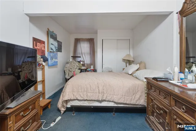 a bedroom with a bed and a flat tv screen on wall