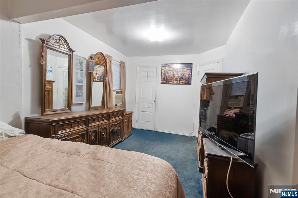 205 North 15th Street Bloomfield, NJ 07003 - Photo 15 of 30 a bedroom with a bed and a flat tv screen on the dresser