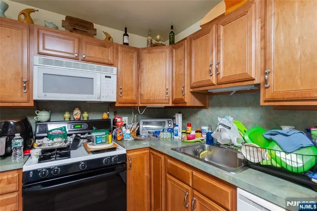 a kitchen with stainless steel appliances granite countertop a sink a stove and a microwave