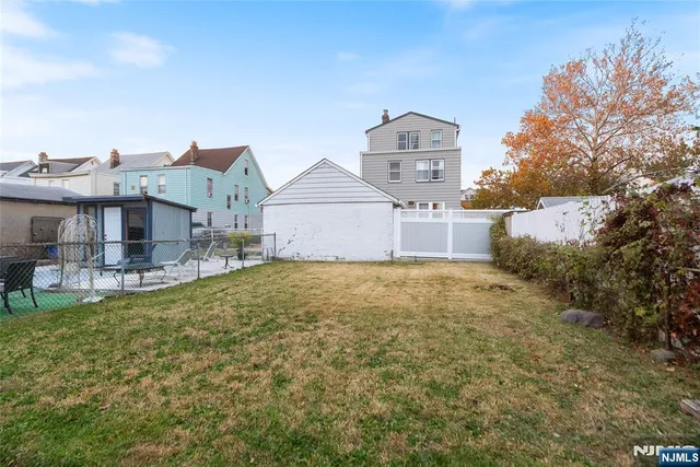 a front view of a house with a yard and large trees