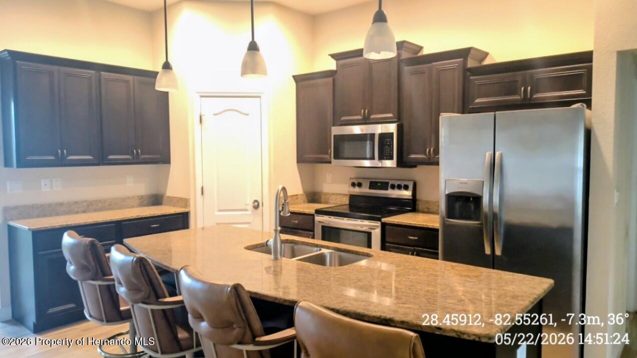 10244 Heathcliff Street Spring Hill, FL 34608 - Photo 3 of 30 a kitchen with stainless steel appliances wooden floor dining table and chairs