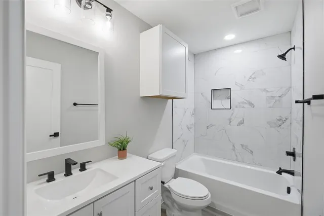 a bathroom with a sink a toilet and shower