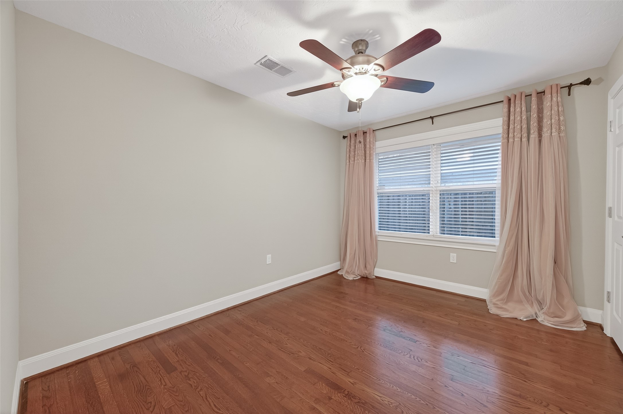 5323 Briarbend Drive Houston, TX 77096 - Photo 19 of 38 an empty room with wooden floor and windows