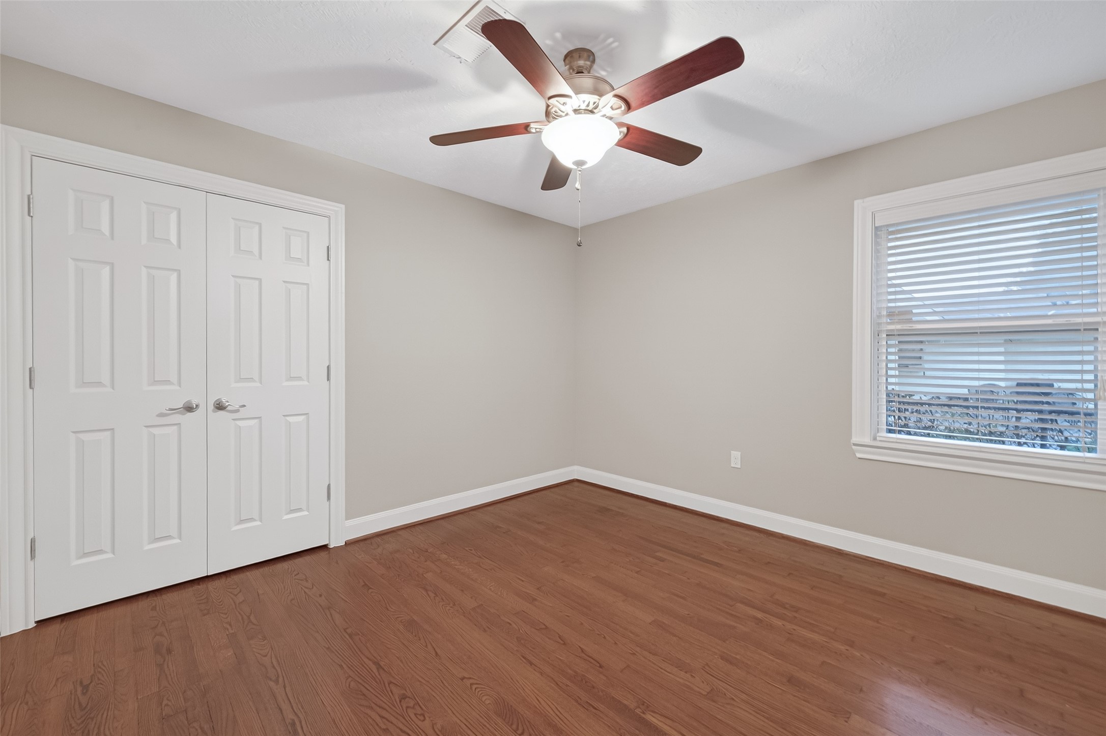 5323 Briarbend Drive Houston, TX 77096 - Photo 21 of 38 an empty room with wooden floor ceiling fan and windows