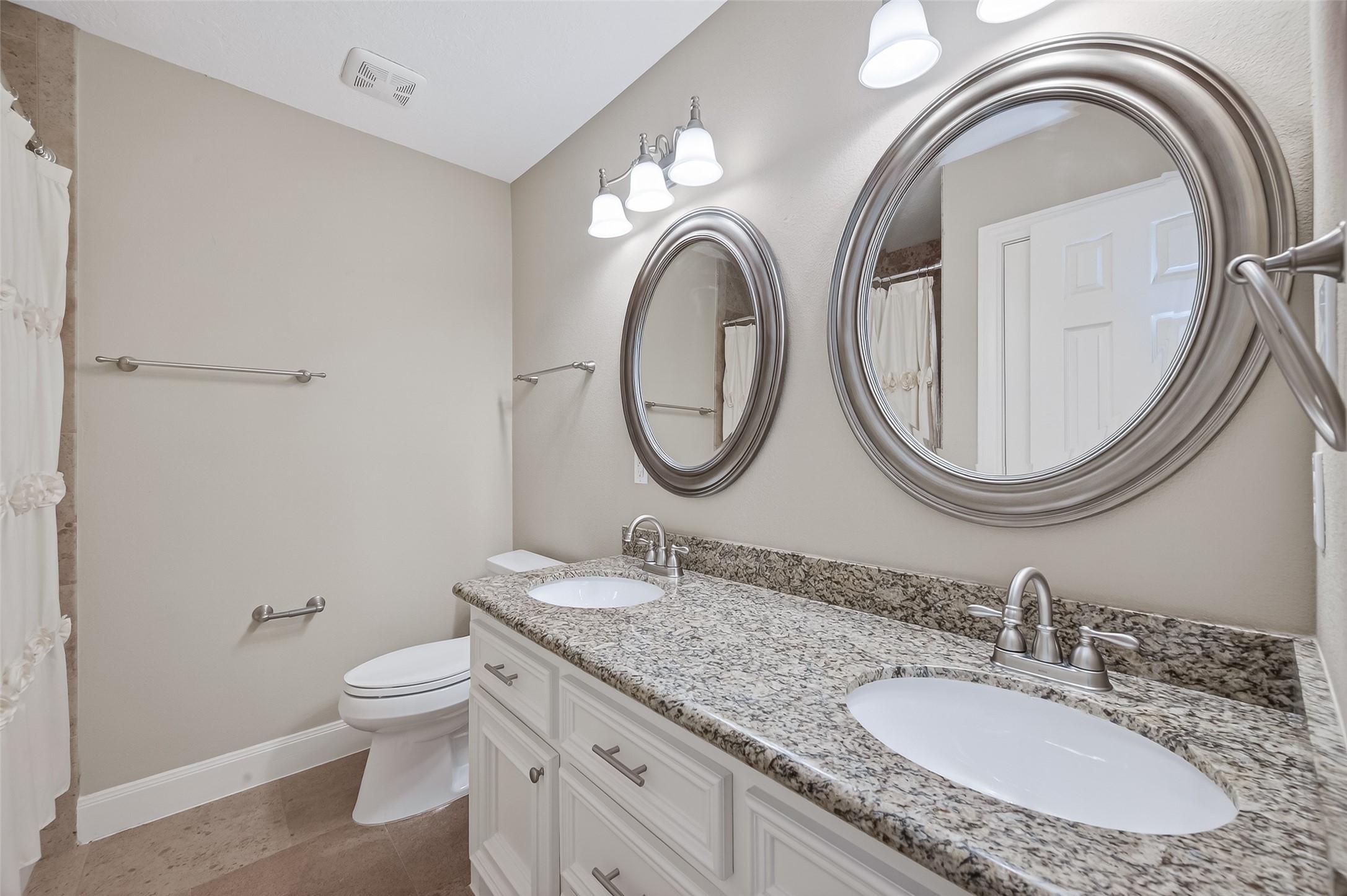 5323 Briarbend Drive Houston, TX 77096 - Photo 22 of 38 a bathroom with a granite countertop toilet a sink and a mirror
