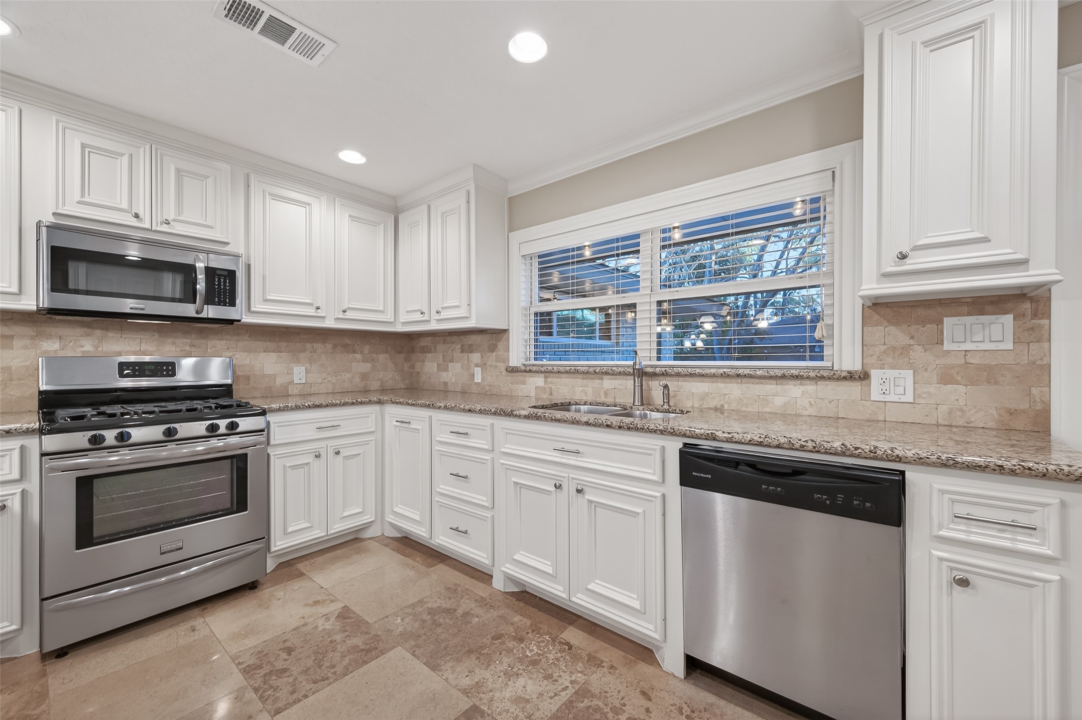 5323 Briarbend Drive Houston, TX 77096 - Photo 10 of 38 a kitchen with granite countertop white cabinets and stainless steel appliances