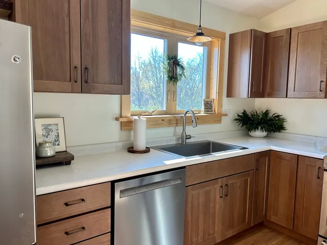 a kitchen with stainless steel appliances granite countertop a sink a counter space and cabinets
