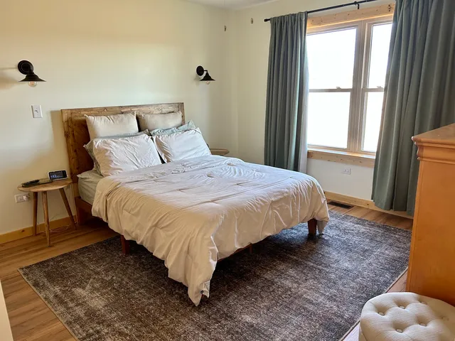 a large bed sitting in a bedroom next to a window