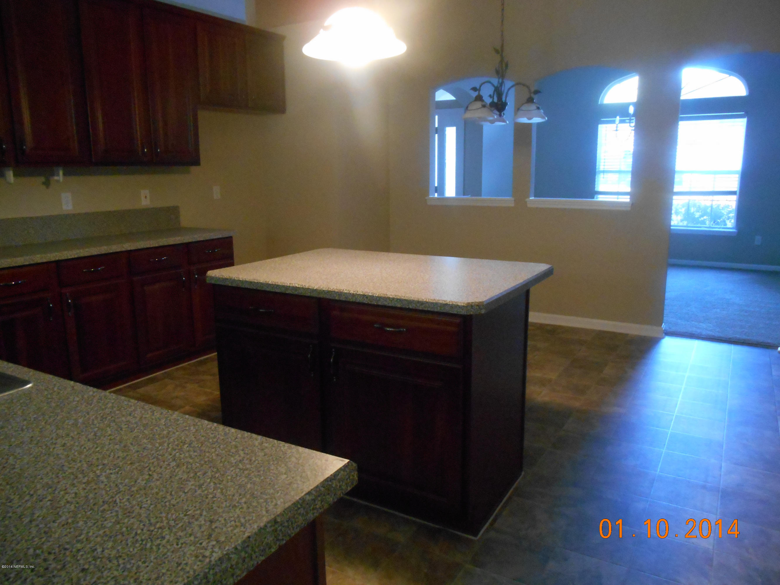 97226 Castle Ridge Drive Yulee, FL 32097 - Photo 8 of 15 a kitchen with a wooden floor and cabinets