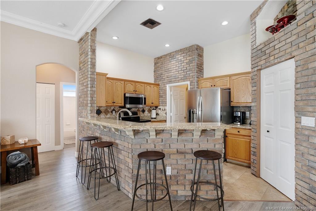 3532 Southwest Margela Street Port St. Lucie, FL 34953 - Photo 9 of 29 a kitchen with stainless steel appliances kitchen island granite countertop a sink and cabinets