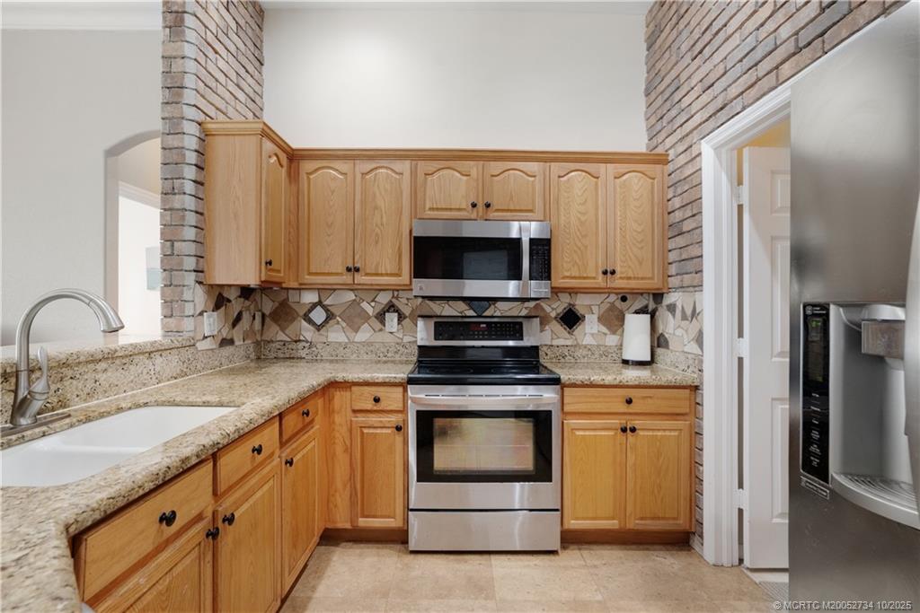 3532 Southwest Margela Street Port St. Lucie, FL 34953 - Photo 10 of 29 a kitchen with granite countertop a sink stainless steel appliances and cabinets