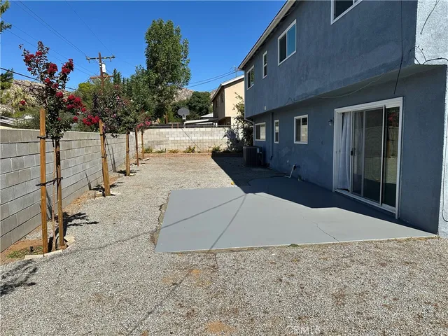 a view of a patio with table and chairs and wooden fence
