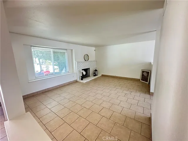 an empty room with windows and chandelier fan