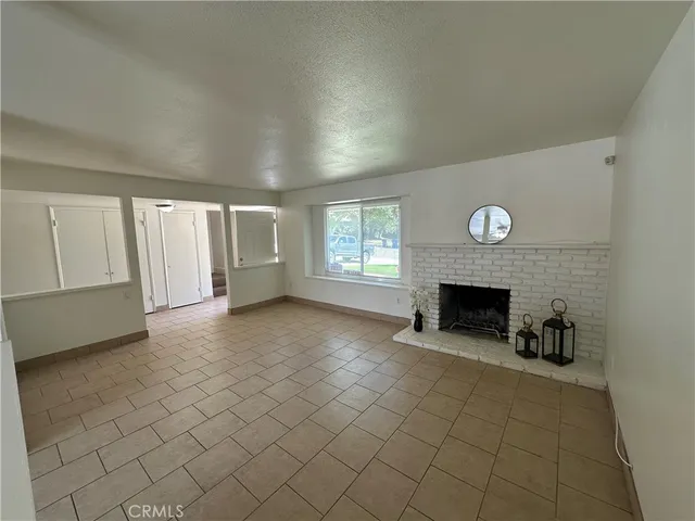 a living room with stainless steel appliances furniture a rug and a window