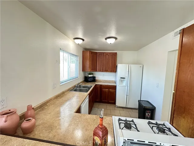 a view of a kitchen with kitchen island a counter top space appliances and cabinets