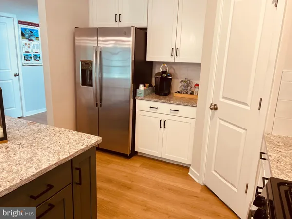 a kitchen with a sink refrigerator and cabinets