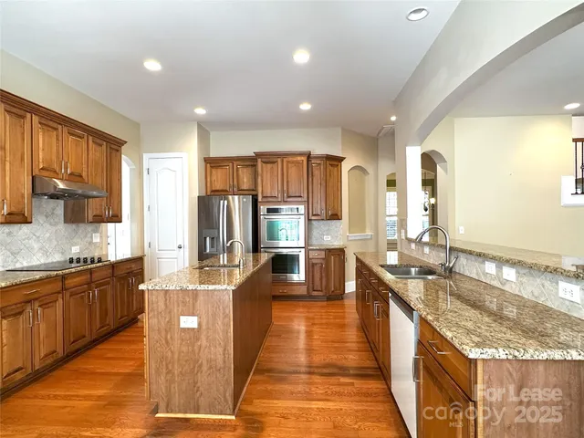 a large kitchen with kitchen island granite countertop a large counter top appliances and cabinets