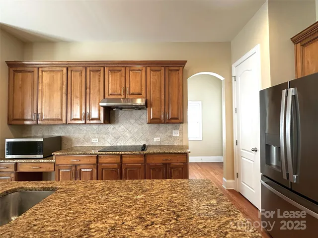 a kitchen with stainless steel appliances granite countertop a refrigerator sink and cabinets
