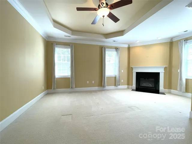 a view of an empty room with a fireplace and a window