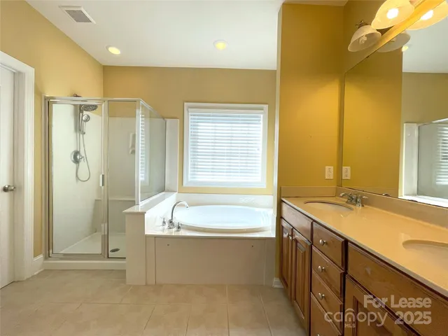 a spacious bathroom with a granite countertop tub sink and shower