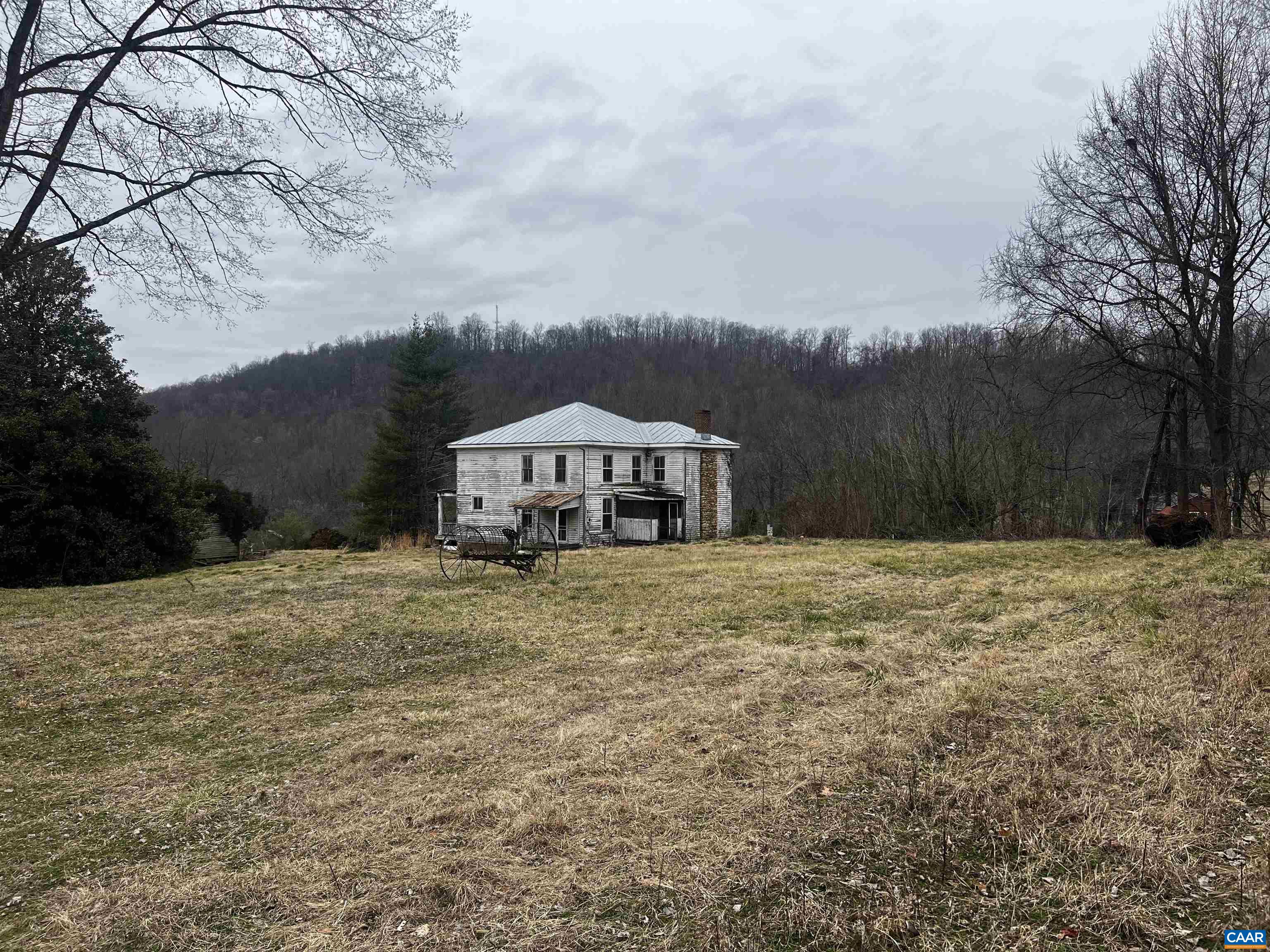 a yellow and red house sitting in the middle of a big yard