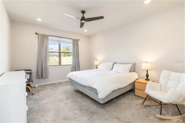 a large bedroom with a bed and a lamp