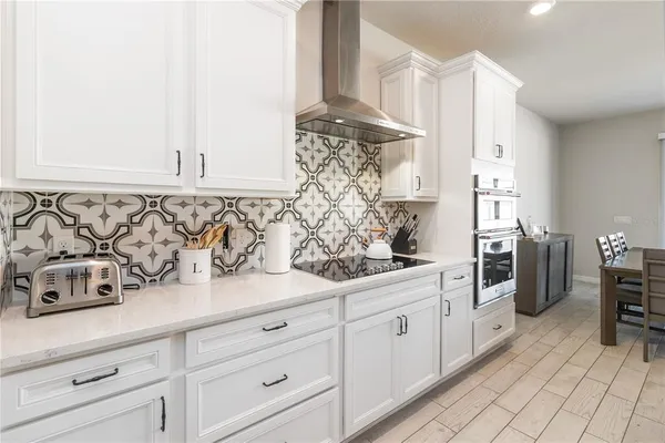 a kitchen with granite countertop white cabinets and white appliances
