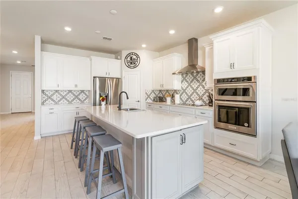 a kitchen with stainless steel appliances kitchen island granite countertop a stove a sink and a refrigerator
